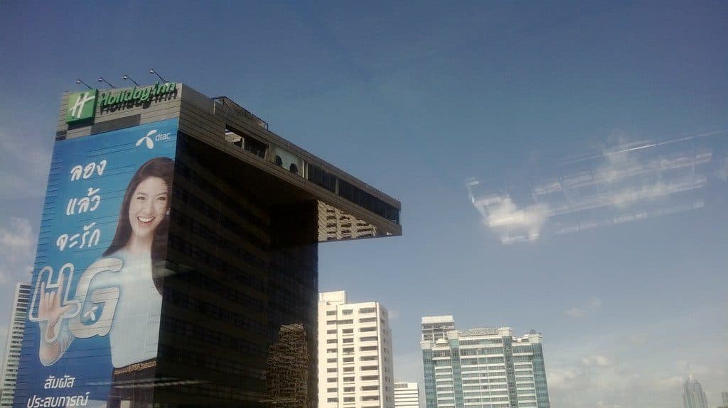 スクンビット通りに面した Holiday Inn Bangkok Sukhumvit。上層階が張り出した黒い棟の屋上に Holiday Inn の看板が乗る